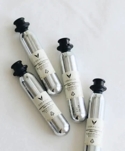A group of silver bottles with black caps, including a close-up of a bottle and a tube. These Coravin Pure™ Sparkling CO2 Capsules preserve the taste and effervescence of sparkling wine for up to 4 weeks. Compatible with the Coravin Sparkling™ System.
