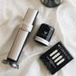 Coravin Sparkling Wine Preservation System with silver box, black and silver container, and white objects on a bed.