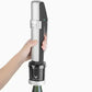 A hand holding a Coravin Sparkling Wine Preservation System with a bottle and black and silver device.