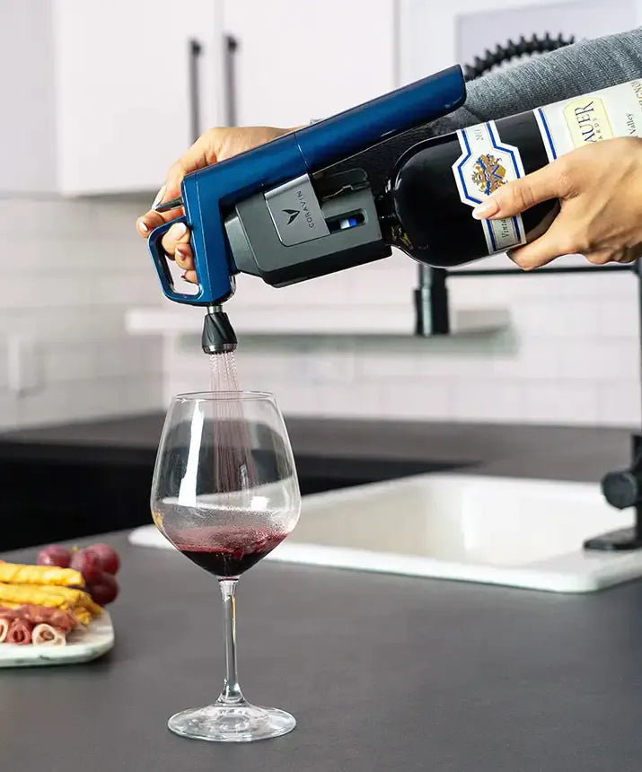 A person pouring wine into a glass using the Coravin Timeless Six+ Wine Preservation System.