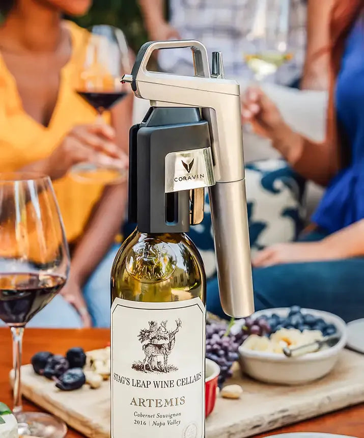 A wine bottle with a corkscrew, part of the Coravin Timeless Six+ Wine Preservation System.