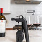 Coravin Timeless Three+ Wine Preservation System with wine bottle, corkscrew, and accessories.