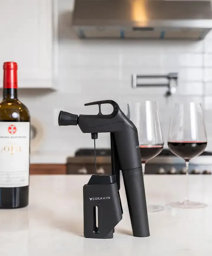 Coravin Timeless Three+ Wine Preservation System with wine bottle, corkscrew, and accessories.