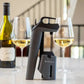 Coravin Timeless Three SL Wine Preservation System: A wine bottle and glass of wine, along with a device for preserving still wines for weeks, months, or even years.