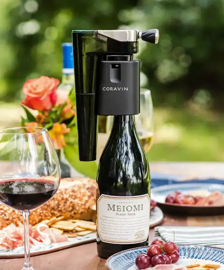 Coravin Timeless Aerator: A wine bottle and glass on a table, with the aerator attached to the Coravin system.