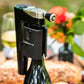 A close-up of a Coravin Timeless Aerator attached to a bottle of wine with a corkscrew.