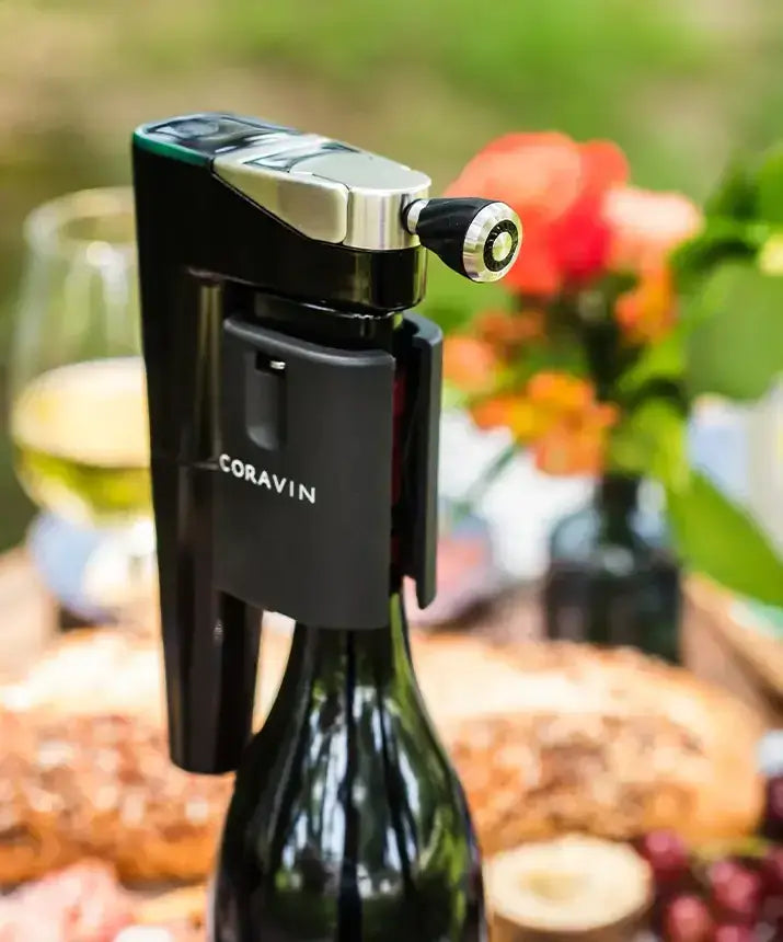 A close-up of a Coravin Timeless Aerator attached to a bottle of wine with a corkscrew.