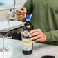 A person opening a bottle of wine with Coravin Pivot™ Stoppers 6 Pack.