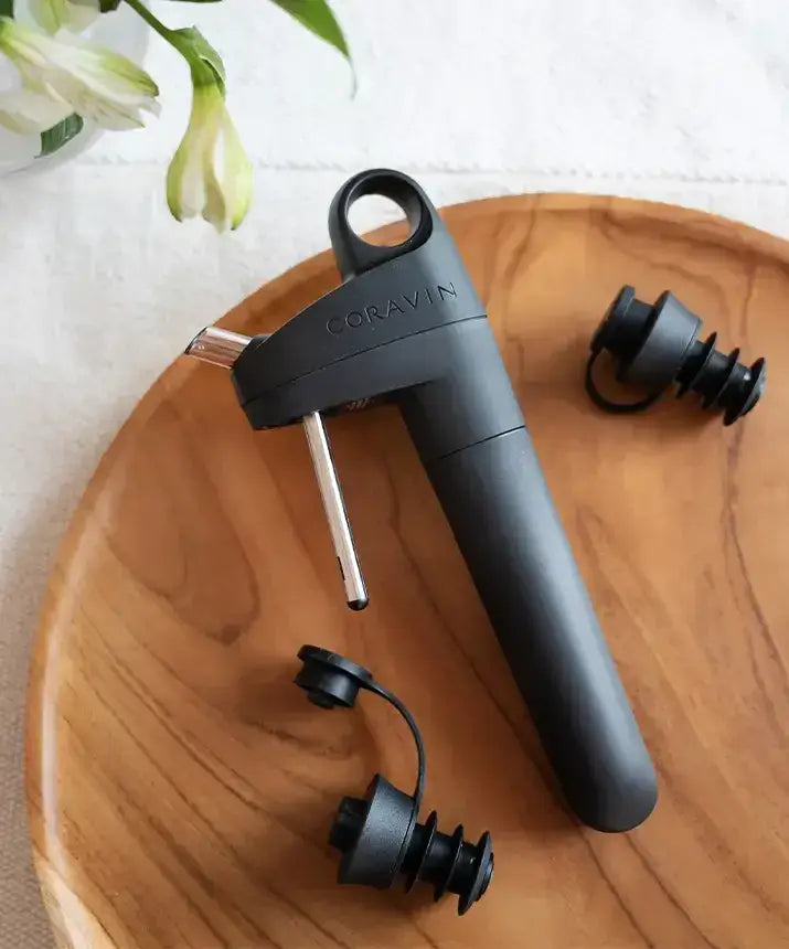 Coravin Pivot™ Stoppers 6 Pack - A black bottle opener on a wooden plate, compatible with Coravin Pivot™ Systems.