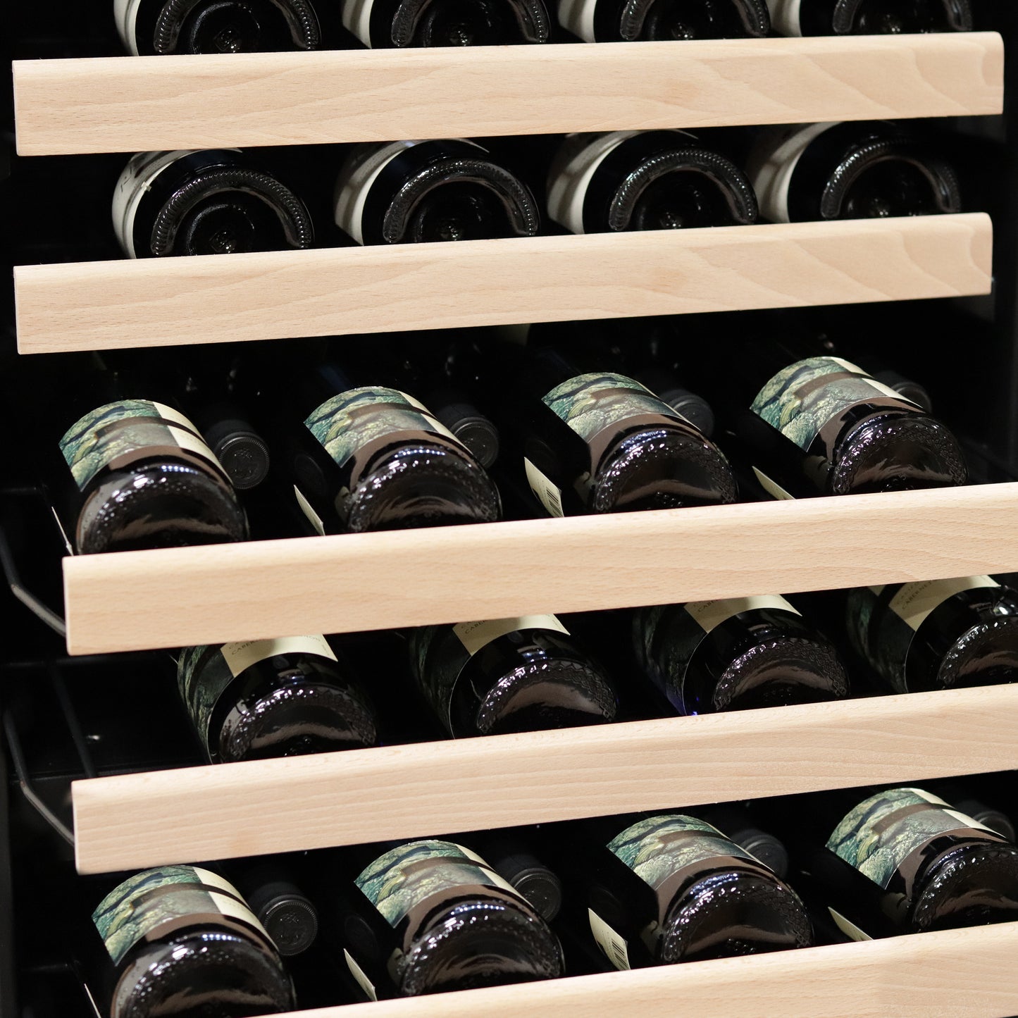 a wine rack with bottles of wine on display in a stainless steel dual zone compressor wine refrigerator